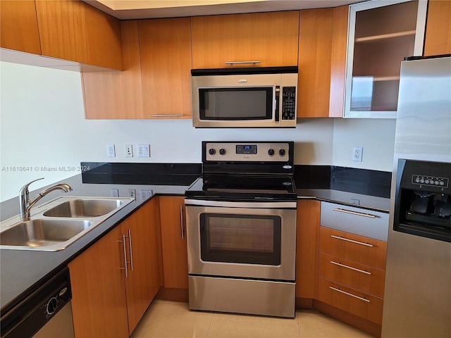 kitchen with sink, stainless steel appliances, and light tile patterned floors