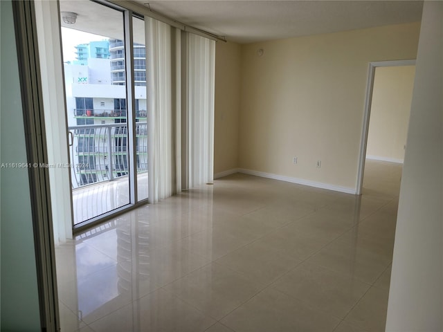 spare room with light tile patterned floors, plenty of natural light, and expansive windows