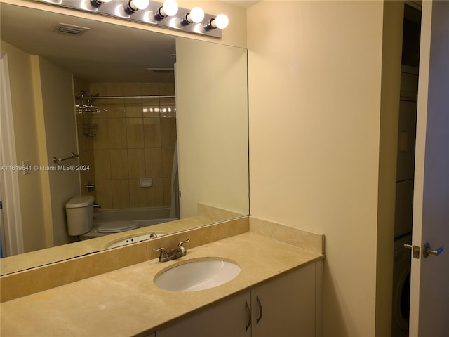 full bathroom with vanity, toilet, washer / dryer, and tiled shower / bath combo