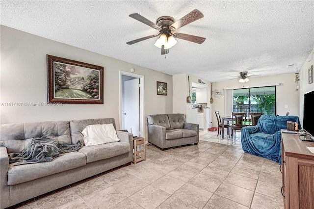 tiled living room with a textured ceiling and ceiling fan