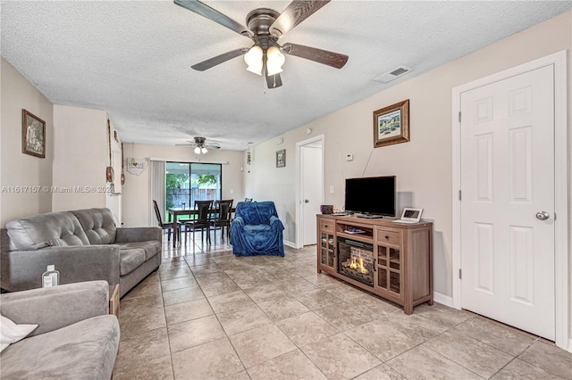 living room featuring light tile patterned flooring, a textured ceiling, and ceiling fan