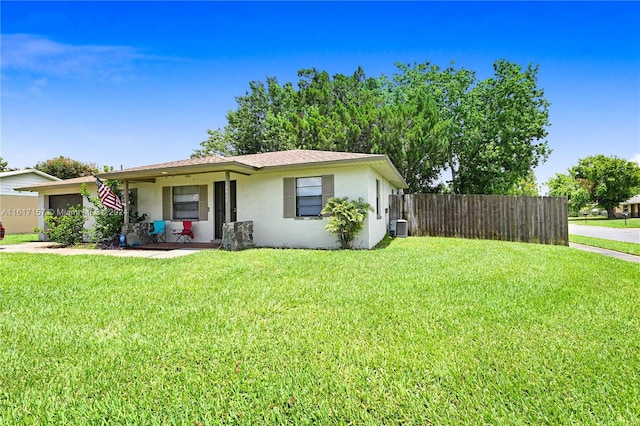 ranch-style home featuring a garage, central AC, and a front yard