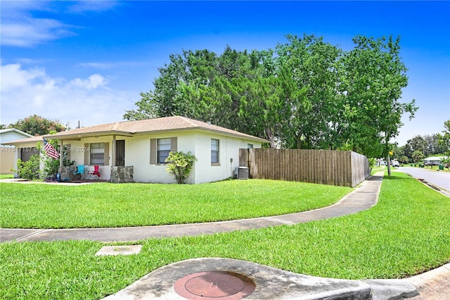 view of front of property with central AC and a front yard