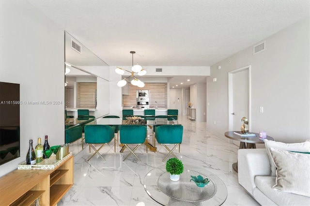 tiled living room featuring a chandelier and a textured ceiling