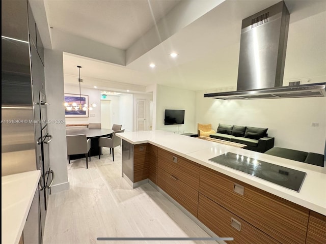 kitchen featuring black electric cooktop, hanging light fixtures, light hardwood / wood-style floors, range hood, and a notable chandelier