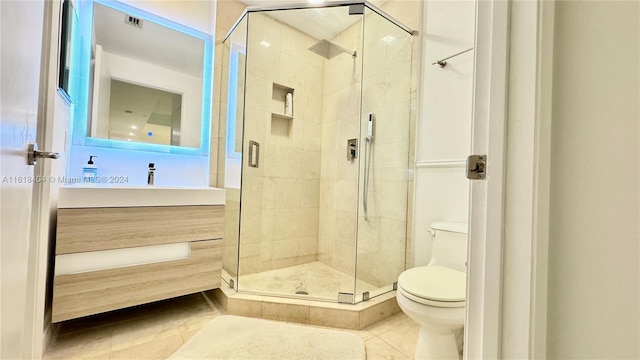 bathroom with vanity, toilet, walk in shower, and tile patterned flooring