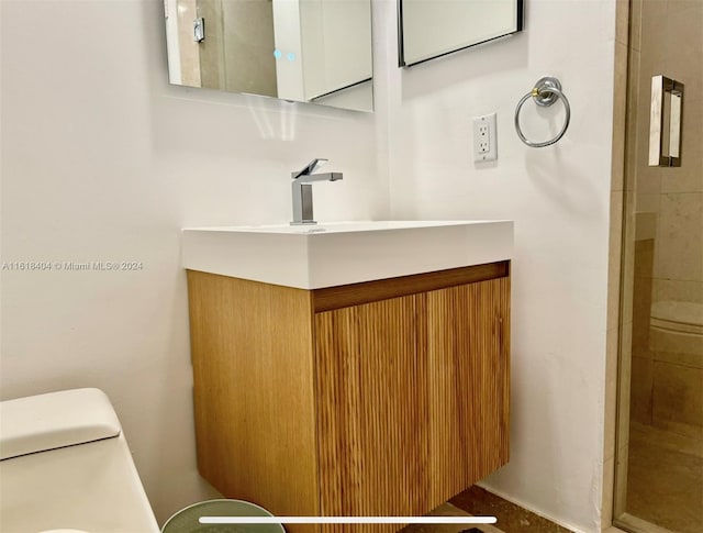 bathroom with vanity, toilet, and an enclosed shower