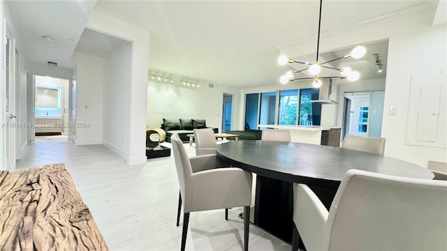 dining space with light hardwood / wood-style flooring and an inviting chandelier