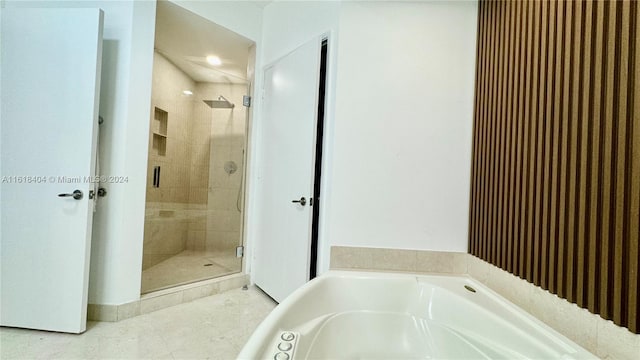 bathroom featuring tile patterned flooring and shower with separate bathtub