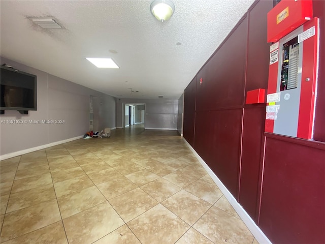 interior space featuring a textured ceiling and light tile patterned floors