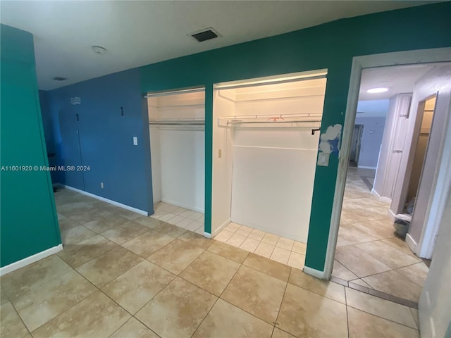 unfurnished bedroom with tile patterned flooring and a closet