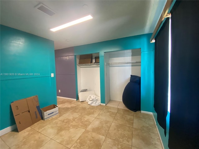 bedroom featuring light tile patterned flooring and a closet