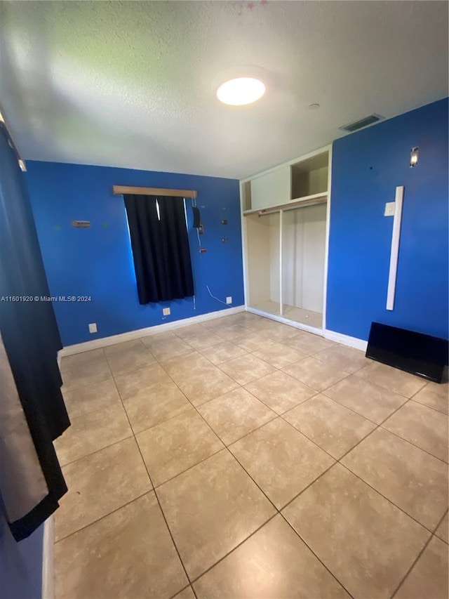 unfurnished bedroom featuring tile patterned flooring and a closet