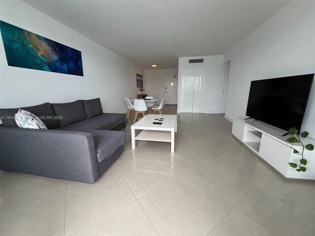 living room featuring a water view, expansive windows, and light tile patterned floors