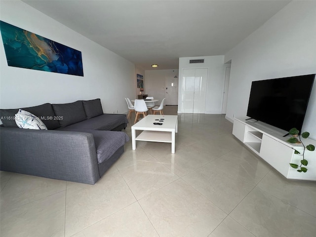 living area featuring light tile patterned flooring and visible vents