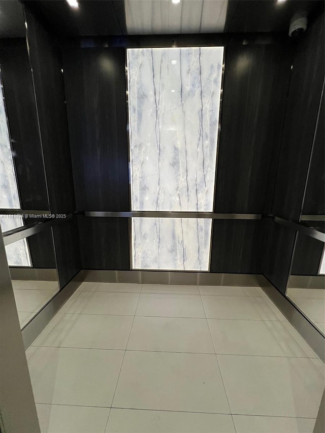 empty room with elevator and tile patterned flooring