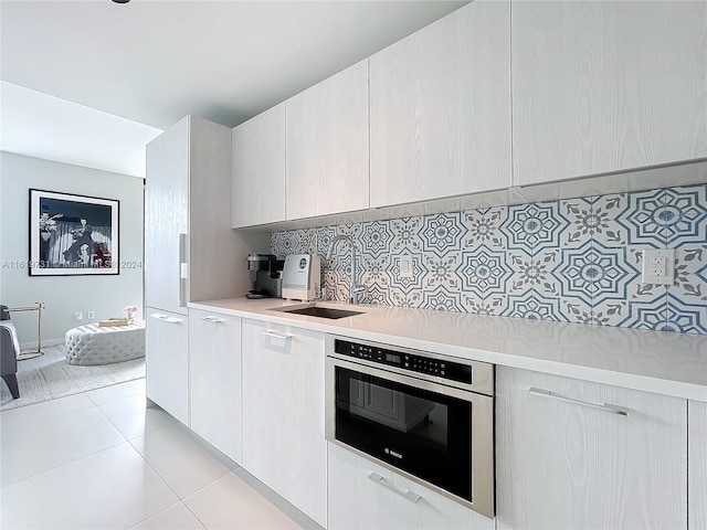 kitchen featuring decorative backsplash, oven, and light tile patterned floors