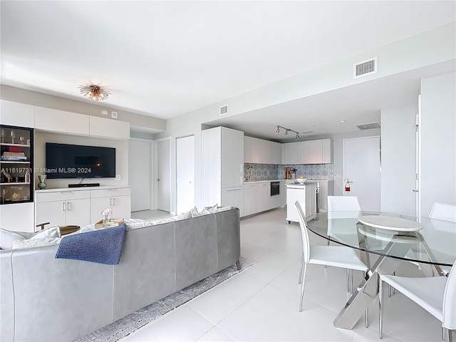 living room with track lighting and light tile patterned floors