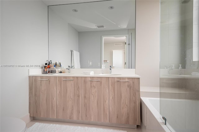 bathroom featuring toilet, tile patterned flooring, and dual bowl vanity