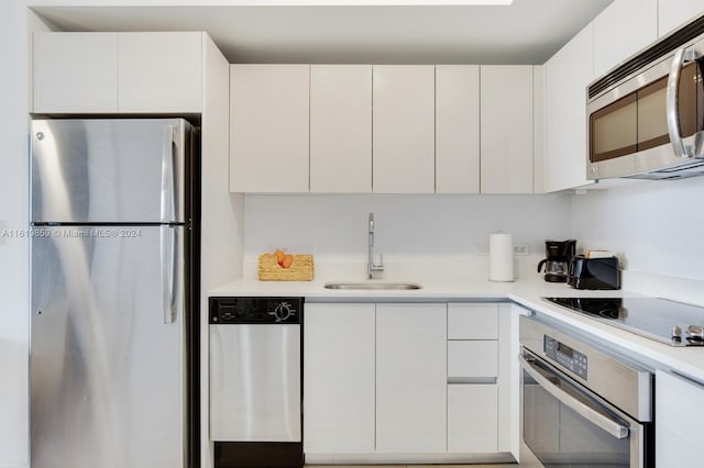 kitchen with white cabinets, appliances with stainless steel finishes, and sink