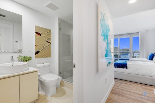 bathroom with a shower with shower door, vanity, hardwood / wood-style flooring, and toilet