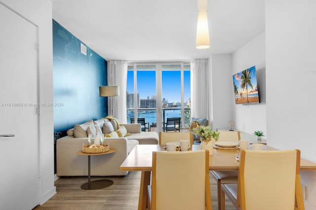 dining area with a water view, hardwood / wood-style flooring, and floor to ceiling windows