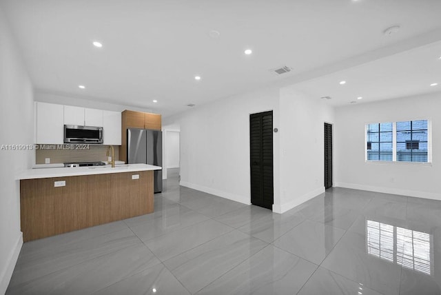 kitchen with decorative backsplash, white cabinetry, sink, light tile patterned flooring, and stainless steel appliances