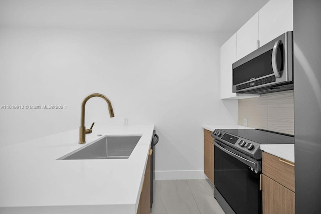 kitchen featuring decorative backsplash, white cabinets, light tile patterned floors, sink, and range with electric stovetop