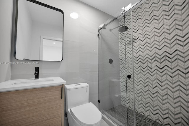 bathroom featuring toilet, tile walls, an enclosed shower, and vanity