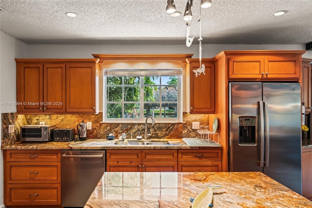 kitchen with stainless steel appliances, light stone countertops, decorative backsplash, and sink