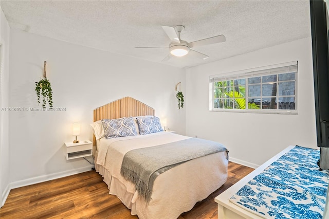 bedroom with a textured ceiling, ceiling fan, and dark hardwood / wood-style flooring