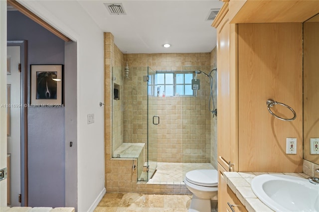 bathroom with vanity, a shower with shower door, and toilet