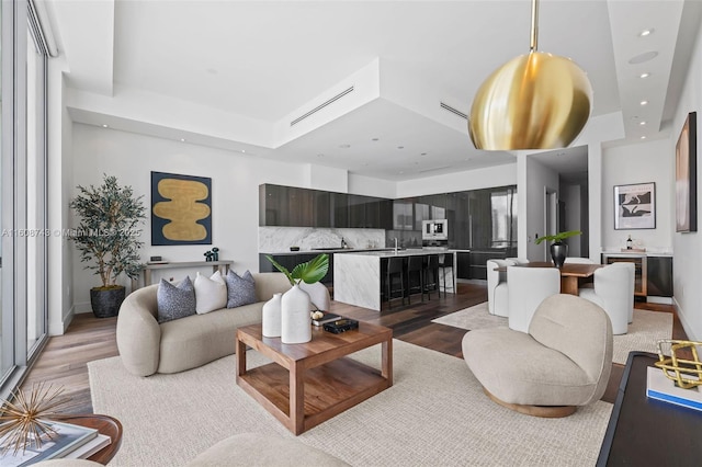 living room with baseboards, recessed lighting, and light wood-style floors