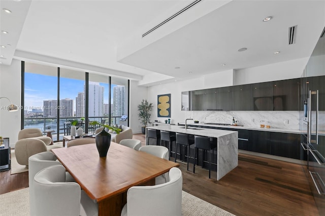 dining area featuring dark wood-style floors, a view of city, floor to ceiling windows, recessed lighting, and visible vents