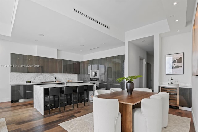 dining room with visible vents, wine cooler, wood finished floors, wet bar, and recessed lighting