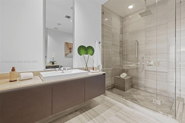 bathroom with visible vents, a shower stall, and vanity