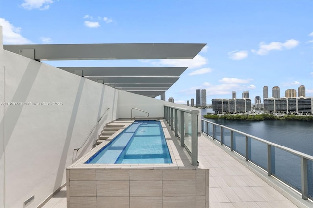 view of swimming pool featuring a water view and a city view