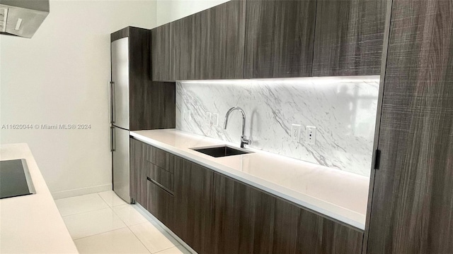 kitchen with tasteful backsplash, dark brown cabinets, sink, light tile patterned floors, and exhaust hood