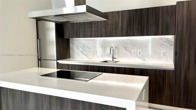 kitchen with tasteful backsplash, sink, dark brown cabinetry, island exhaust hood, and black electric stovetop