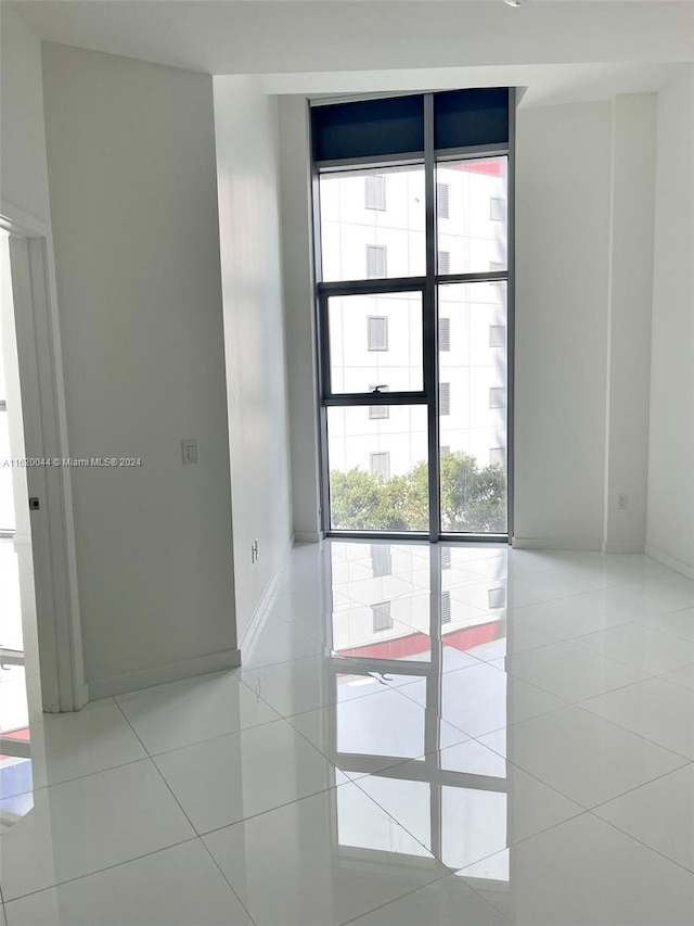 tiled spare room with floor to ceiling windows