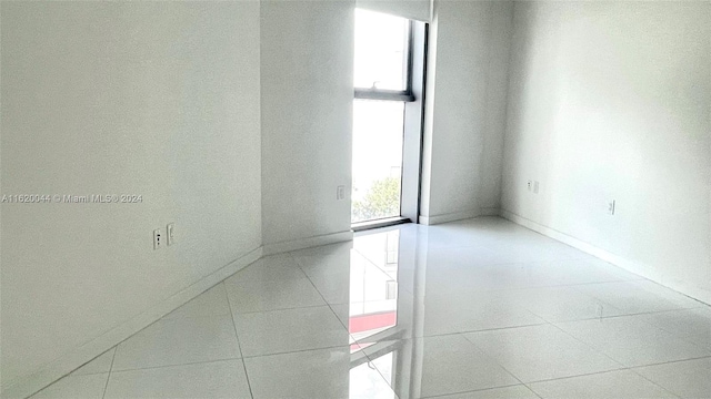 spare room with a wealth of natural light and tile patterned floors