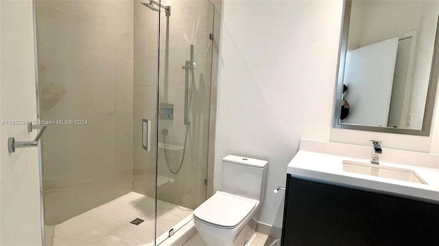 bathroom featuring vanity, toilet, and a shower with shower door