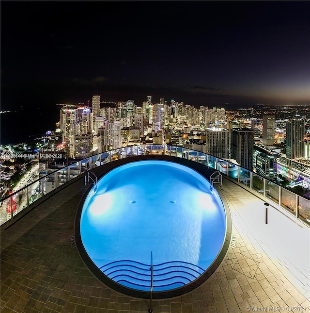 view of pool at twilight