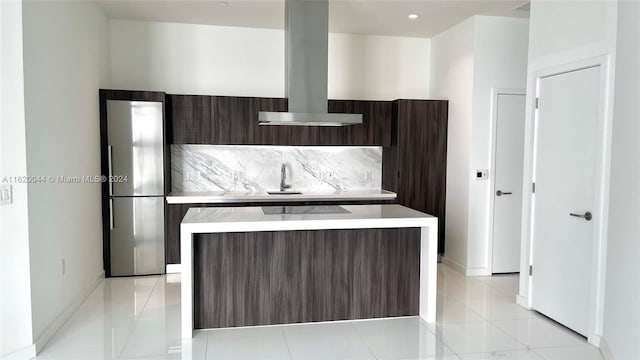 kitchen with island exhaust hood, dark brown cabinets, a center island, and stainless steel fridge