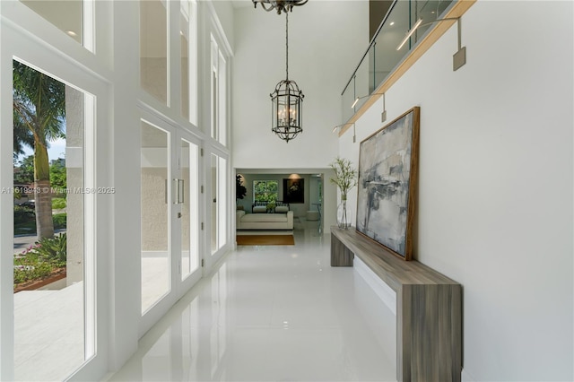 hallway with a notable chandelier and a towering ceiling