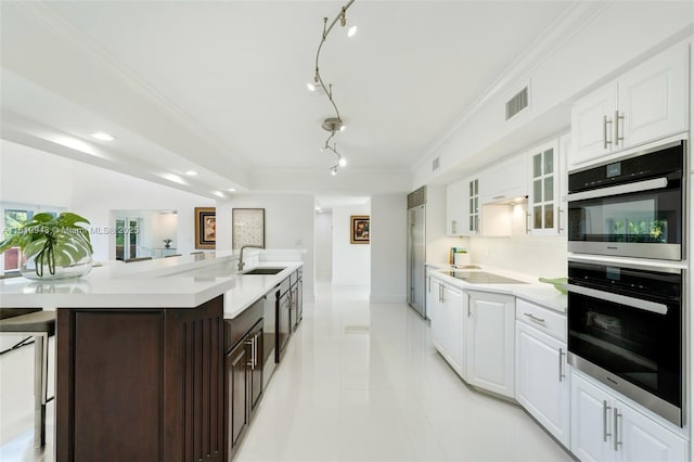 kitchen featuring sink, white cabinets, tasteful backsplash, and appliances with stainless steel finishes