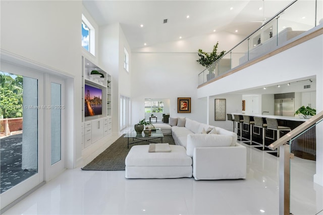 tiled living room with a towering ceiling and a healthy amount of sunlight