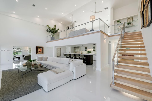 living room with ceiling fan and high vaulted ceiling