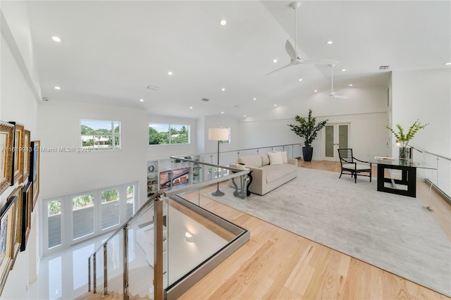 game room with light wood-type flooring and high vaulted ceiling