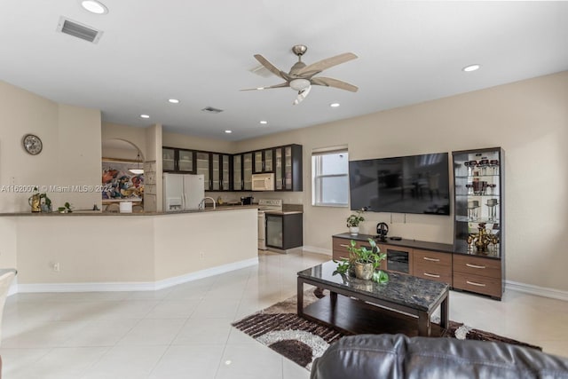 living room with sink, ceiling fan, and light tile patterned floors